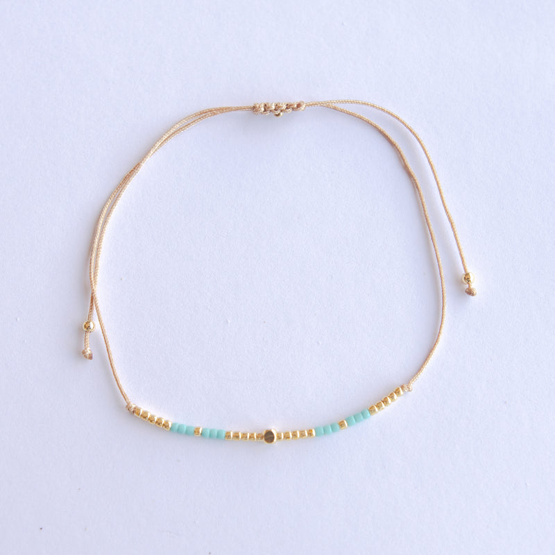 Add a pop of subtle color to your style with our Gleam Beads Adjustable Anklets. Featuring delicate colorful and gold beads on a silky cotton string, these adjustable anklets are perfect for layering, with five colors available to create your unique combinations.