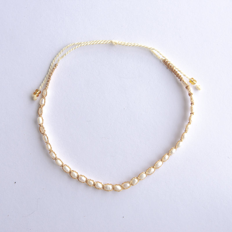 Elevate your style with our Gold String Anklet featuring genuine freshwater pearls. This trendy anklet is perfect for adding a touch of coastal charm to any outfit, whether at the beach or in the city.