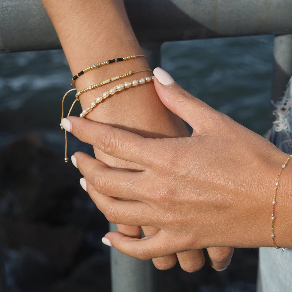 Elevate your style with our Gold String Bracelet featuring genuine freshwater pearls. This trendy bracelet is perfect for adding a touch of coastal charm to any outfit, whether at the beach or in the city. Made with durable, high-quality materials, it offers both style and comfort with its adjustable fit. Don’t forget to check out our matching anklet to complete your look!