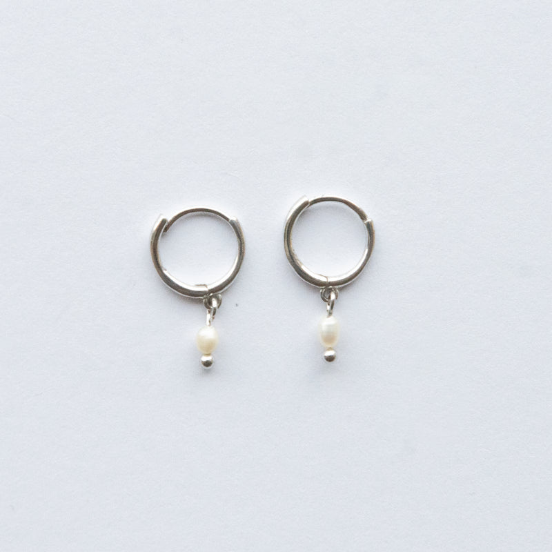 Available in both silver and gold, these Huggie Freshwater Pearl Earrings are designed to complement any wardrobe choice.